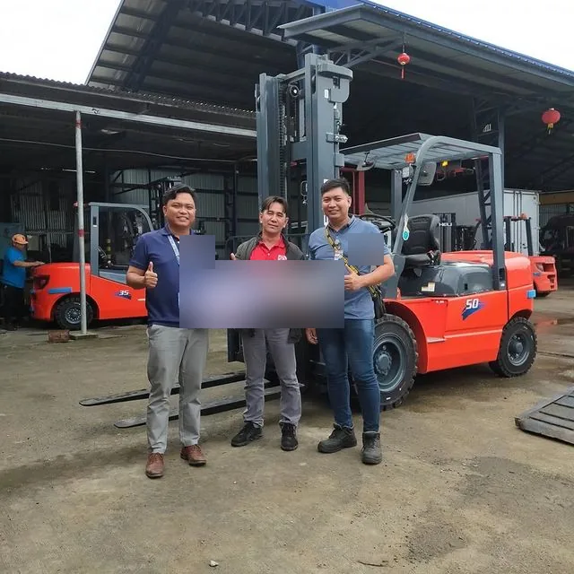Vladimir and two customers with the sold key beside a 5 ton forklift