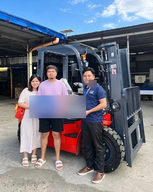 Two customers and Vladimir with the sold key in front of a new forklift