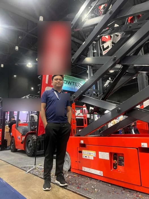 Vladimir Barasigan standing beside equipment at a trade show