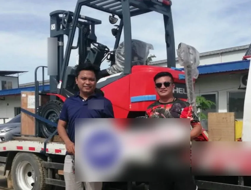 Vladimir and a customer holding the key as a forklift is loaded for delivery